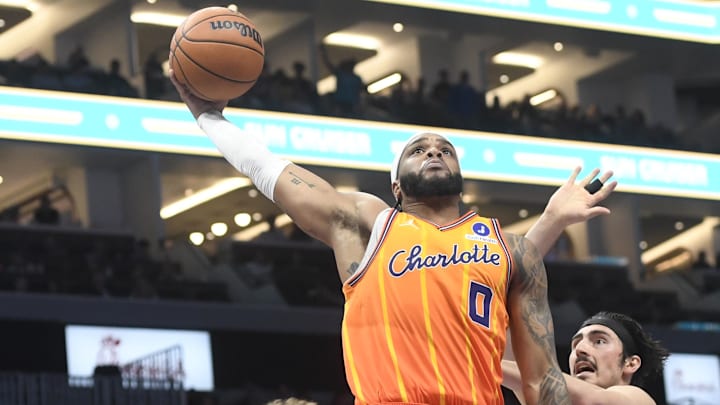 Mar 6, 2026; Charlotte, North Carolina, USA;  Charlotte Hornets forward Miles Bridges (0) drives past Miami Heat guard Kasparas Jakucionis (25) and forward Jaime Jaquez Jr. (11) to dunk during the second half at the Spectrum Center. Mandatory Credit: Sam Sharpe-Imagn Images