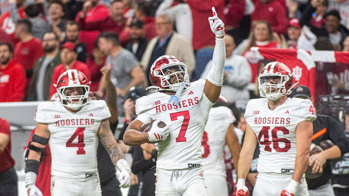 Indiana's Louis Moore (7) celebrates with Aiden Fisher (4) and Isaiah Jones (46) after his interception during the Indiana versus Ohio State Big Ten Championship football game at Lucas Oil Stadium on Saturday, Dec. 6, 2025.