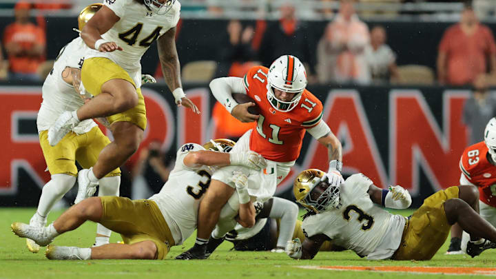 Aug 31, 2025; Miami Gardens, Florida, USA; Miami Hurricanes quarterback Carson Beck (11) rushes the ball against the Notre Dame Fighting Irish during the second quarter at Hard Rock Stadium. Mandatory Credit: Sam Navarro-Imagn Images