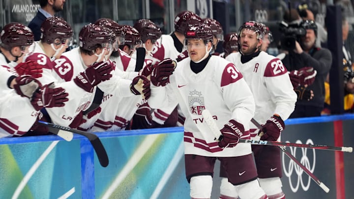 Feb 14, 2026; Milan, Italy; Eduards Tralmaks of Latvia celebrates with teammates after scoring their third goal during a Group C men's ice hockey game during the Milano Cortina 2026 Olympic Winter Games at Milano Rho Ice Hockey Arena. Mandatory Credit: Amber Searls-Imagn Images Feb 14, 2026; Milan, Italy; Eduards Tralmaks of Latvia celebrates with teammates after scoring their third goal during a Group C men's ice hockey game during the Milano Cortina 2026 Olympic Winter Games at Milano Rho Ice Hockey Arena. Mandatory Credit: Amber Searls-Imagn Images