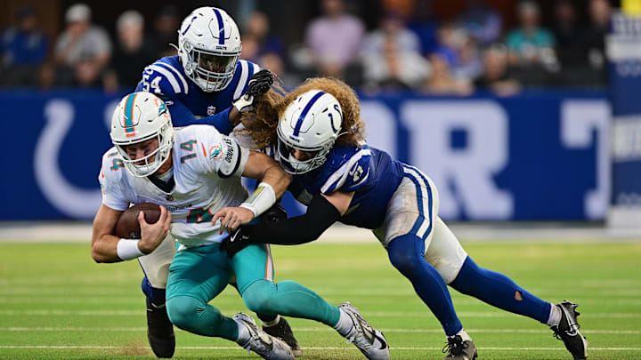 Miami Dolphins quarterback Tim Boyle (14) is tackled by Indianapolis Colts defensive end Dayo Odeyingbo (54) and linebacker Grant Stuard (41) during the second half at Lucas Oil Stadium.