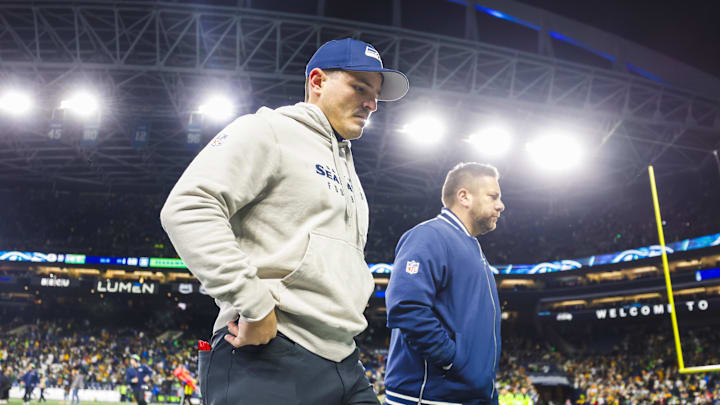 Dec 15, 2024; Seattle, Washington, USA; Seattle Seahawks head coach Mike Macdonald, left, walks to the locker room following a loss against the Green Bay Packers at Lumen Field. Mandatory Credit: Joe Nicholson-Imagn Images