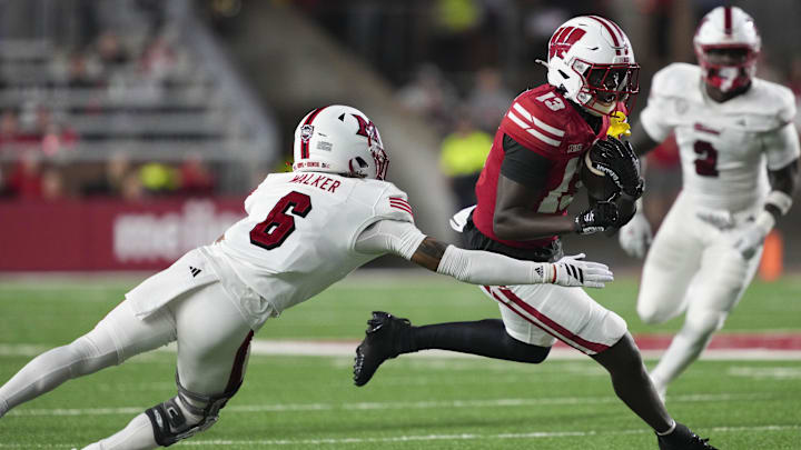 Aug 28, 2025; Madison, Wisconsin, USA;  Wisconsin Badgers wide receiver Eugene Hilton Jr. (13) rushes with the football against Miami (OH) RedHawks defensive back Adrian Walker Jr. (6) during the third quarter at Camp Randall Stadium. Mandatory Credit: Jeff Hanisch-Imagn Images