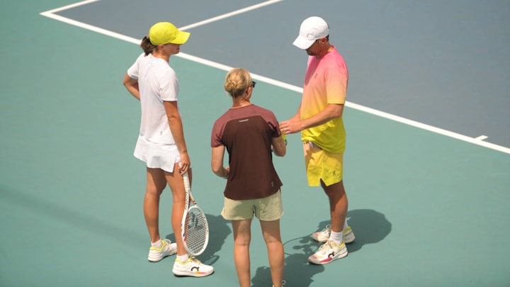 Iga Swiatek speaks with Wim Fissette and Daria Abramowicz on the practice court.
