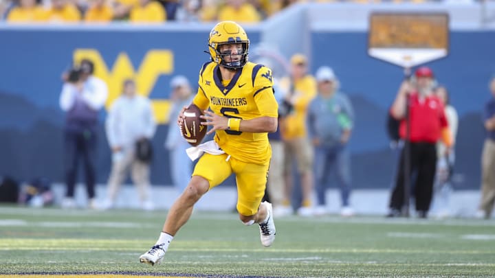 Sep 7, 2024; Morgantown, West Virginia, USA; West Virginia Mountaineers quarterback Garrett Greene (6) rolls out to pass during the first quarter against the Albany Great Danes at Mountaineer Field at Milan Puskar Stadium. Mandatory Credit: Ben Queen-Imagn Images Sep 7, 2024; Morgantown, West Virginia, USA; West Virginia Mountaineers quarterback Garrett Greene (6) rolls out to pass during the first quarter against the Albany Great Danes at Mountaineer Field at Milan Puskar Stadium. Mandatory Credit: Ben Queen-Imagn Images