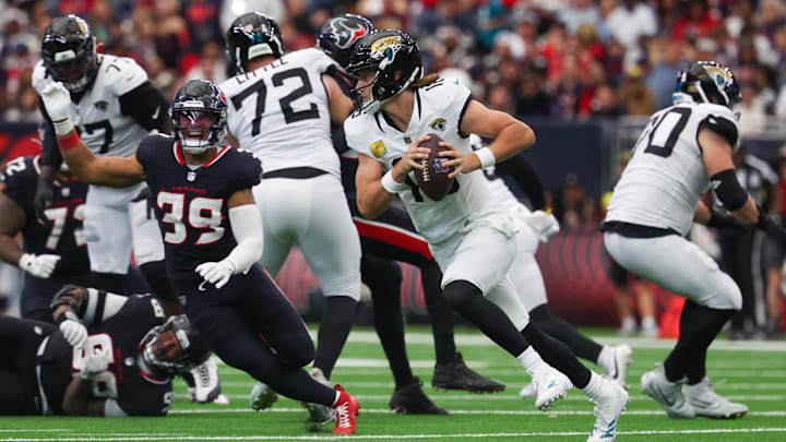 Nov 9, 2025; Houston, Texas, USA; Jacksonville Jaguars quarterback Trevor Lawrence (16) rolls out as Houston Texans linebacker Henry To'oTo'o (39) defends during the second half at NRG Stadium. Mandatory Credit: Thomas Shea-Imagn Images