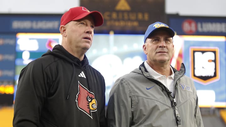 Oct 14, 2023; Pittsburgh, Pennsylvania, USA;  Louisville Cardinals head coach Jeff Brohm (left) and Pittsburgh Panthers head coach Pat Narduzzi (right) talk at mid-field before their teams play at Acrisure Stadium. Mandatory Credit: Charles LeClaire-USA TODAY Sports