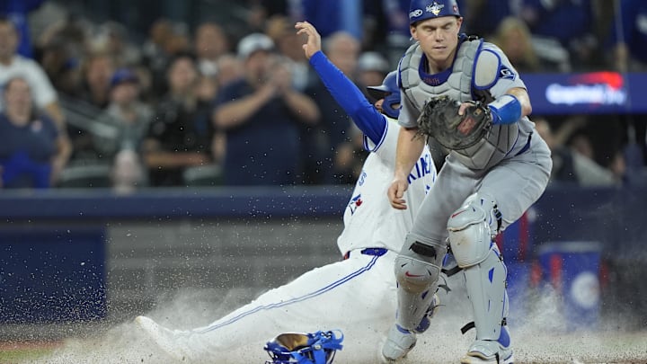 Toronto Blue Jays player Isiah Kiner-Falefa slides into home plate past Los Angeles Dodgers catcher Will Smith. Toronto Blue Jays player Isiah Kiner-Falefa slides into home plate past Los Angeles Dodgers catcher Will Smith.