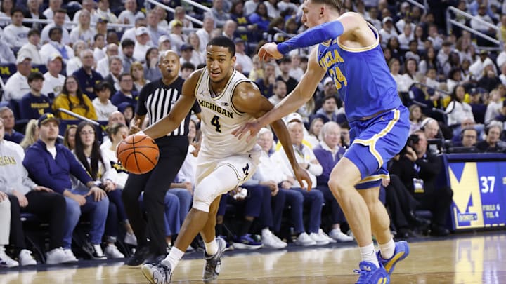 Feb 14, 2026; Ann Arbor, Michigan, USA; Michigan Wolverines guard Nimari Burnett (4) dribbles on UCLA Bruins forward Tyler Bilodeau (34) in the first half at Crisler Center. Mandatory Credit: Rick Osentoski-Imagn Images