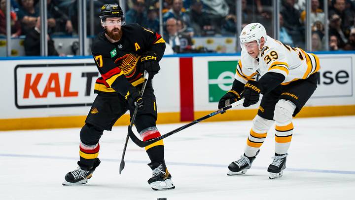 Jan 3, 2026; Vancouver, British Columbia, CAN; Boston Bruins forward Morgan Geekie (39) defends against Vancouver Canucks defenseman Filip Hronek (17) in the third period at Rogers Arena. Mandatory Credit: Bob Frid-Imagn Images