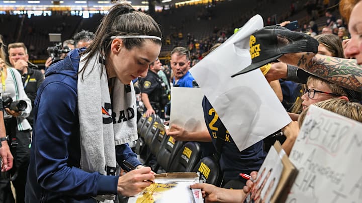 May 4, 2025; Iowa City, IA, USA; Indiana Fever guard Caitlin Clark (22) signs autographs for fans after the game against the Brazil National Team at Carver-Haweye Arena. Mandatory Credit: Jeffrey Becker-Imagn Images
