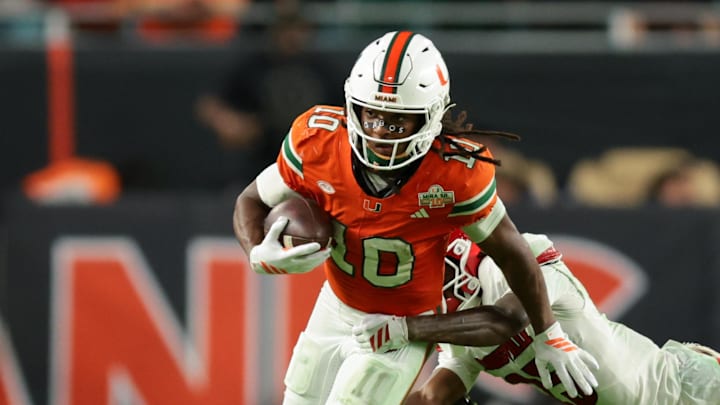 Oct 17, 2025; Miami Gardens, Florida, USA; Miami Hurricanes wide receiver Malachi Toney (10) carries the football against Louisville Cardinals defensive back Tayon Holloway (25) during the fourth quarter at Hard Rock Stadium. Mandatory Credit: Sam Navarro-Imagn Images