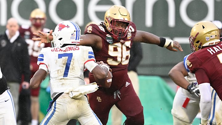 Dec 28, 2023; Boston, MA, USA; Boston College Eagles defensive tackle Cam Horsley (96) reaches out for Southern Methodist Mustangs quarterback Kevin Jennings (7) during the second half at Fenway Park. Mandatory Credit: Eric Canha-Imagn Images