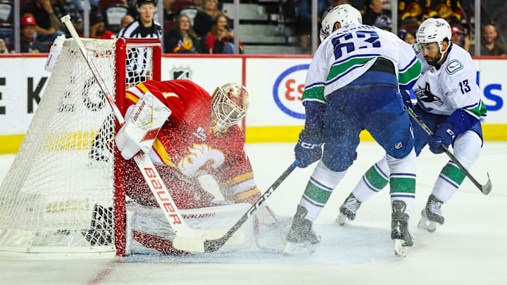 Oct 1, 2025; Calgary, Alberta, CAN; Vancouver Canucks center Max Sasson (63) scores a goal against Calgary Flames goaltender Devin Cooley (1) during the third period at Scotiabank Saddledome. Mandatory Credit: Sergei Belski-Imagn Images