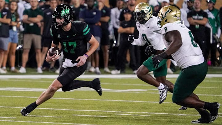 North Texas quarterback Drew Mestemaker (17) scrambles with the ball as South Florida cornerback Jarvis Lee (0) and defensive lineman Traevon Mitchell (8)