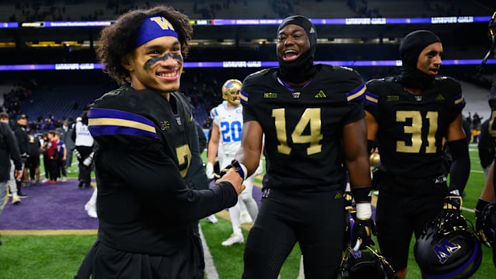 Huskies quarterback Demond Williams Jr. (2) and edge rusher Milton Hopkins Jr. (14) celebrate after beating UCLA.