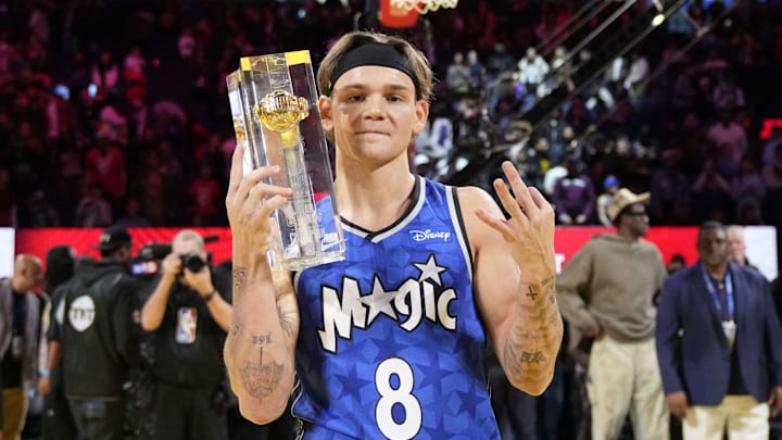 McClung celebrates with the trophy after winning the slam dunk competition. 