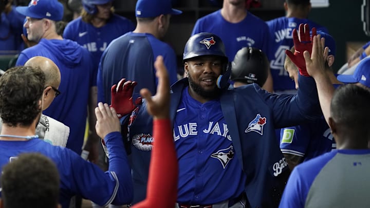 Sep 19, 2024; Arlington, Texas, USA; Toronto Blue Jays first baseman Vladimir Guerrero Jr. (27) is greeted in the dugout after hitting a solo home run during the seventh inning against the Texas Rangers at Globe Life Field.