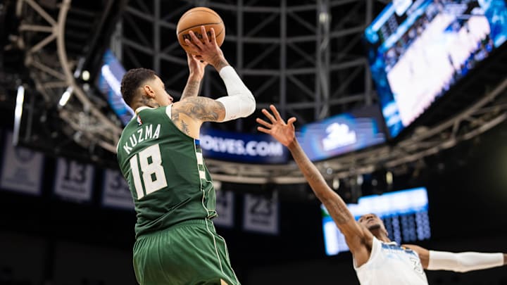 Feb 12, 2025; Minneapolis, Minnesota, USA; Milwaukee Bucks forward Kyle Kuzma (18) shoots against Minnesota Timberwolves forward Jaden McDaniels (3) in the fourth quarter at Target Center. Mandatory Credit: Brad Rempel-Imagn Images