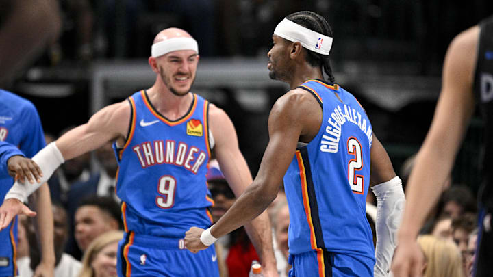 Mar 1, 2026; Dallas, Texas, USA; Oklahoma City Thunder guard Alex Caruso (9) and guard Shai Gilgeous-Alexander (2) celebrate after Gilgeous-Alexander dunks the ball against the Dallas Mavericks during the second quarter at the American Airlines Center. Mandatory Credit: Jerome Miron-Imagn Images