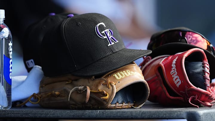A Colorado Rockies hat sits on top of a glove.