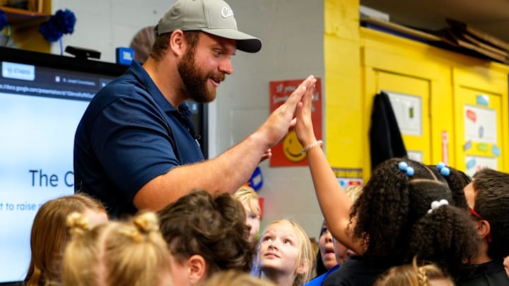 Cincinnati Bengals center Ted Karras (64) high fives a third grader on Tuesday, Nov. 28, 2023, at St. Joseph s Consolidated School in Hamilton, Ohio. Over a year ago Karras began selling The Cincy Hat, a project that gives 100% of the proceeds from hat sales to The Village of Merici, an Indianapolis-based living community and services provider for adults with disabilities. Cincinnati Bengals center Ted Karras (64) high fives a third grader on Tuesday, Nov. 28, 2023, at St. Joseph s Consolidated School in Hamilton, Ohio. Over a year ago Karras began selling The Cincy Hat, a project that gives 100% of the proceeds from hat sales to The Village of Merici, an Indianapolis-based living community and services provider for adults with disabilities.
