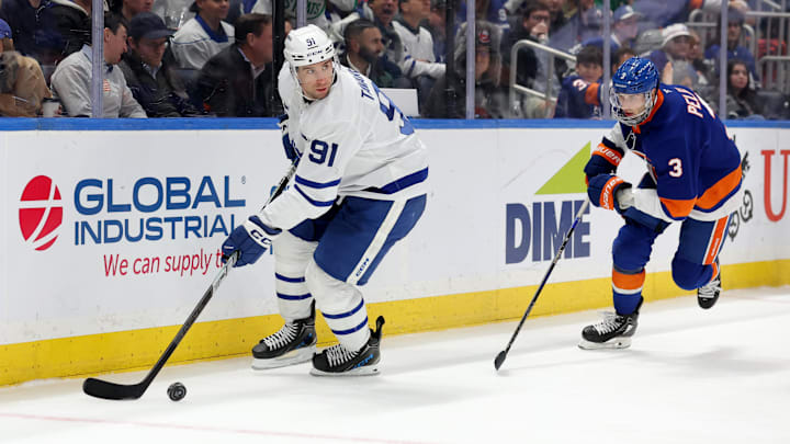 Jan 2, 2025; Elmont, New York, USA; Toronto Maple Leafs center John Tavares (91) controls the puck against New York Islanders defenseman Adam Pelech (3) during the third period at UBS Arena. Mandatory Credit: Brad Penner-Imagn Images
