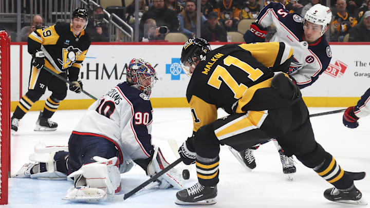 Mar 21, 2025; Pittsburgh, Pennsylvania, USA;  Columbus Blue Jackets goaltender Elvis Merzlikins (90) makes a save against Pittsburgh Penguins center Evgeni Malkin (71) during the third period at PPG Paints Arena. Mandatory Credit: Charles LeClaire-Imagn Images