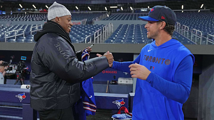 Buffalo Bills WR Joshua Palmer shakes hands with Toronto Blue Jays third base Ernie Clement.
