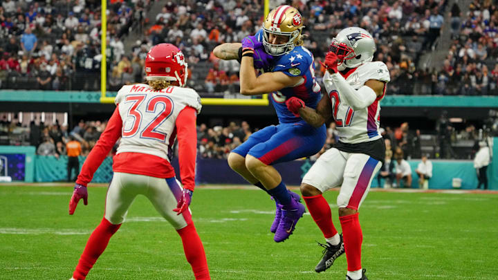 Feb 6, 2022; Paradise, Nevada, USA; NFC tight end George Kittle of the San Francisco 49ers (85) runs with the ball against AFC cornerback JC Jackson of the New England Patriots (27) and strong safety Tyrann Mathieu of the Kansas City Chiefs (32) during the fourth quarter during the Pro Bowl football game at Allegiant Stadium. Mandatory Credit: Kirby Lee-Imagn Images