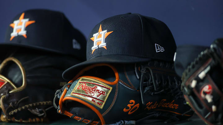 A Houston Astros cap resting on top of a baseball glove