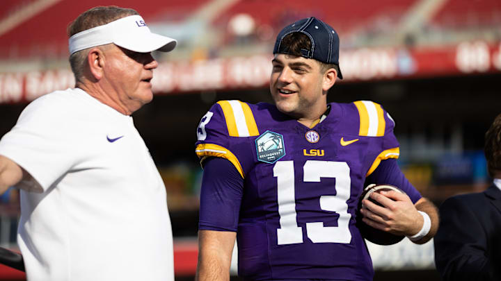 Jan 1, 2024; Tampa, FL, USA; LSU Tigers head coach Brian Kelly and quarterback Garrett Nussmeier (13) talk on the podium after the game against the Wisconsin Badgers at the Reliaquest Bowl at Raymond James Stadium. Mandatory Credit: Matt Pendleton-Imagn Images