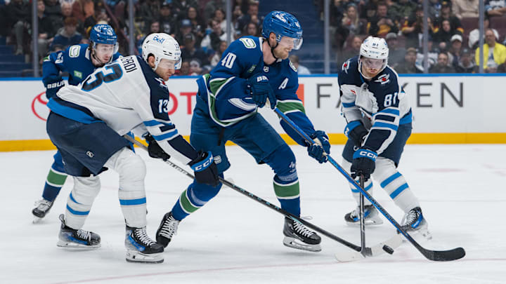 Mar 18, 2025; Vancouver, British Columbia, CAN; Winnipeg Jets forward Gabriel Vilardi (13) and forward Kyle Connor (81) stick scheck Vancouver Canucks forward Elias Pettersson (40) in the third period at Rogers Arena. Mandatory Credit: Bob Frid-Imagn Images