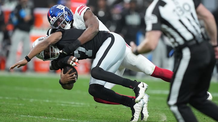 Dec 28, 2025; Paradise, Nevada, USA; Las Vegas Raiders quarterback Geno Smith (7) is tackled by New York Giants outside linebacker Brian Burns (0) in the second half at Allegiant Stadium. Mandatory Credit: Kirby Lee-Imagn Images