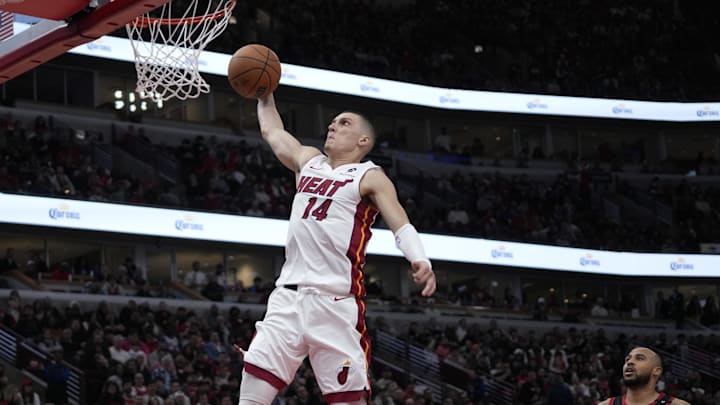 Apr 16, 2025; Chicago, Illinois, USA; Miami Heat guard Tyler Herro (14) goes up for a dunk on Chicago Bulls forward Talen Horton-Tucker (22) during the second half at United Center. Mandatory Credit: David Banks-Imagn Images