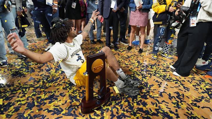 Apr 6, 2026; Indianapolis, IN, USA; Justin Cadeau, the brother of Michigan Wolverines guard Elliot Cadeau (3), with the National Championship Trophy after the National Championship of the Final Four of the men's 2026 NCAA Tournament at Lucas Oil Stadium. Mandatory Credit: Bob Donnan-Imagn Images Apr 6, 2026; Indianapolis, IN, USA; Justin Cadeau, the brother of Michigan Wolverines guard Elliot Cadeau (3), with the National Championship Trophy after the National Championship of the Final Four of the men's 2026 NCAA Tournament at Lucas Oil Stadium. Mandatory Credit: Bob Donnan-Imagn Images