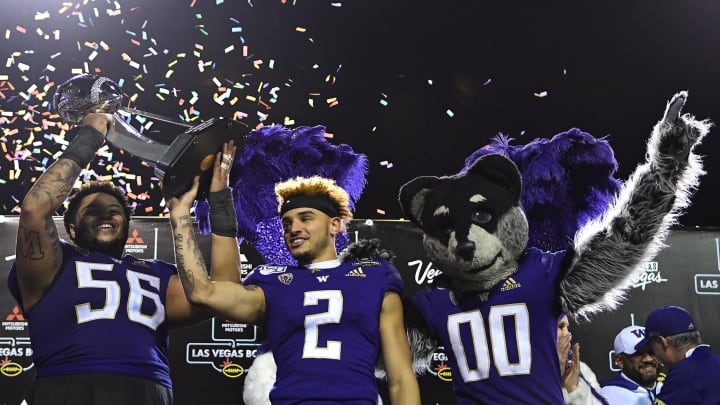 Former Husky center Nick Harris (56) and wide receiver Aaron Fuller (2) hoist the Las Vegas Bowl trophy at Sam Boyd Stadium in 2019. Former Husky center Nick Harris (56) and wide receiver Aaron Fuller (2) hoist the Las Vegas Bowl trophy at Sam Boyd Stadium in 2019.