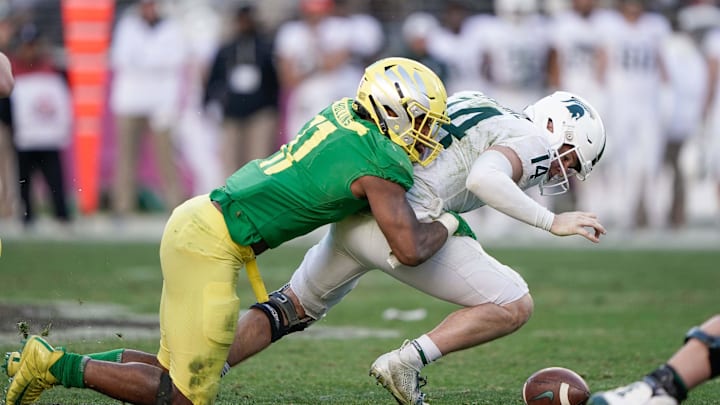 Dec 31, 2018; Santa Clara, CA, USA; Oregon Ducks linebacker Justin Hollins (11) forces a fumble by Michigan State Spartans quarterback Brian Lewerke (14) during the fourth quarter at Levi's Stadium. Mandatory Credit: Stan Szeto-Imagn Images