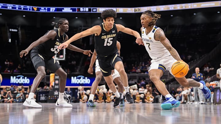 Mar 12, 2025; Kansas City, MO, USA; West Virginia Mountaineers guard Javon Small (7) drives to the basket around Colorado Buffaloes guard Felix Kossaras (15) during the first half at T-Mobile Center. Mandatory Credit: William Purnell-Imagn Images