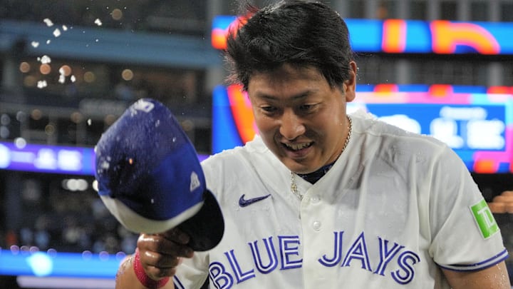Toronto Blue Jays third baseman Kazuma Okamoto flicks ice off of his ball cap after being doused with ice water.