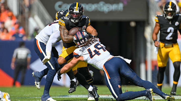 DENVER, CO - SEPTEMBER 15: Pittsburgh running back Jaylen Warren (30) runs the ball as Denver linebacker Alex Singleton (49) tries to pull him down during a game between the Denver Broncos and the Pittsburgh Steelers at Empower Field at Mile High in Denver, CO on September 15, 2024. 
