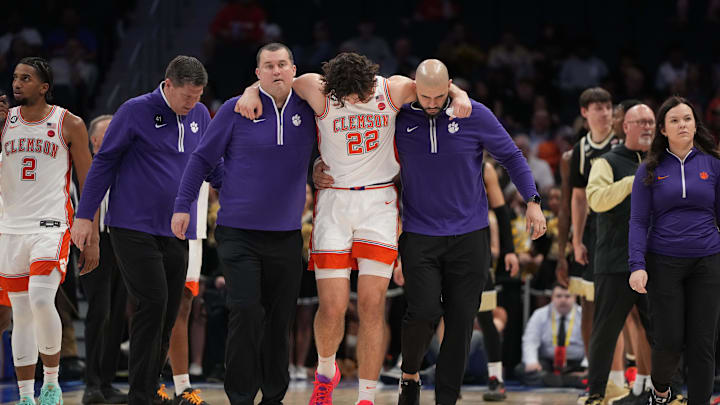 Mar 11, 2026; Charlotte, NC, USA; Clemson Tigers center Carter Welling (22) is helped from the court in the first half at Spectrum Center. Mandatory Credit: Bob Donnan-Imagn Images