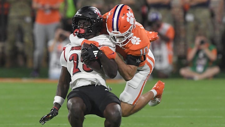 Nov 2, 2024; Clemson, South Carolina, USA; Clemson Tigers cornerback Jeadyn Lukus (10) tackles Louisville Cardinals running back Isaac Brown (25) during the first quarter at Memorial Stadium.
