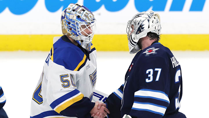 St. Louis Blues goaltender Jordan Binnington and Winnipeg Jets goaltender Connor Hellebuyck shake hands.