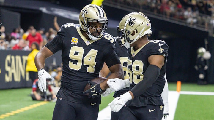 Oct 13, 2024; New Orleans, Louisiana, USA;  New Orleans Saints defensive end Cameron Jordan (94) reacts to intercepting the pass of Tampa Bay Buccaneers quarterback Baker Mayfield (6) during the first half at Caesars Superdome. Mandatory Credit: Stephen Lew-Imagn Images
