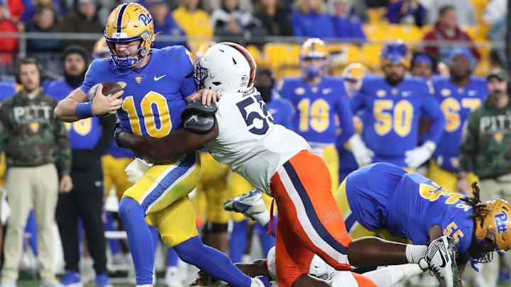 Nov 9, 2024; Pittsburgh, Pennsylvania, USA;  Pittsburgh Panthers quarterback Eli Holstein (10) is tackled by Virginia Cavaliers defensive tackle Anthony Britton (55) during the second quarter at Acrisure Stadium. Mandatory Credit: Charles LeClaire-Imagn Images