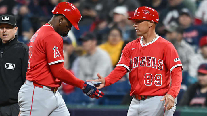 May 30, 2025; Cleveland, Ohio, USA; Los Angeles Angels right fielder Jorge Soler (12) celebrates with infield coach Ryan Goins (89) after hitting an RBI single during the seventh inning against the Cleveland Guardians at Progressive Field. Mandatory Credit: Ken Blaze-Imagn Images