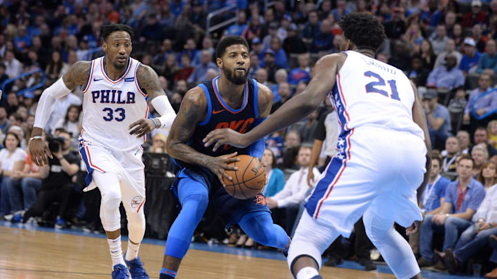Jan 28, 2018; Oklahoma City, OK, USA; Oklahoma City Thunder forward Paul George (13) drives to the basket between Philadelphia 76ers forward Robert Covington (33) and center Joel Embiid (21) during the fourth quarter at Chesapeake Energy Arena. Mandatory Credit: Mark D. Smith-Imagn Images