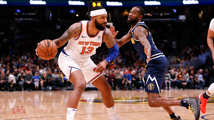 Dec 15, 2019; Denver, CO, USA; New York Knicks forward Marcus Morris Sr. (13) controls the ball as Denver Nuggets guard Will Barton III (5) defends in the third quarter at the Pepsi Center. Mandatory Credit: Isaiah J. Downing-Imagn Images