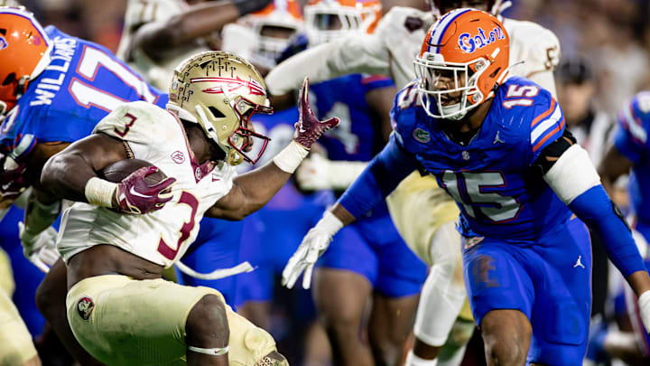 Florida State Seminoles running back Trey Benson (3) attempts to stiff arm Florida Gators linebacker Derek Wingo (15) during the second half at Steve Spurrier Field at Ben Hill Griffin Stadium in Gainesville, FL on Saturday, November 25, 2023. [Matt Pendleton/Gainesville Sun]